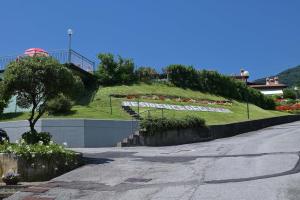 an empty street with a hill with flowers on it at BBQ & Pools GHH in Toscolano Maderno