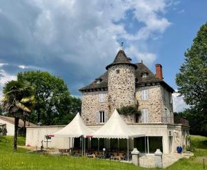 an old castle with a tent in front of it at La Chatelleraie in Saint-Étienne-de-Maurs