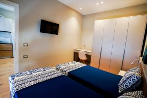 a bedroom with a blue bed and a desk at Klei’s Daily Apartment in Tirana +2 photos