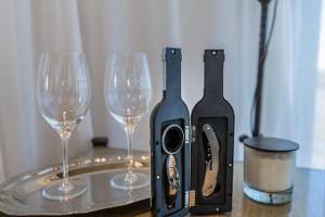 two wine glasses are next to a bottle of wine at Las Magnolias Bodega Boutique in Gualeguaychú