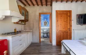 a kitchen with white cabinets and a bed in a room at Fienile Olivo, art of living Tuscany in Torre