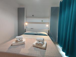 1 dormitorio con 1 cama con toallas en Marzamemi - Appartamento Girasole al Borgo 84, en Marzamemi