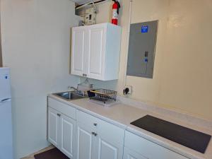 a kitchen counter with a sink and a mirror at The Vacay Inn in Lauderdale Lakes