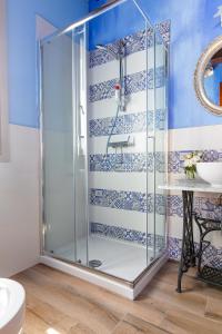 a shower with a glass door in a bathroom at Fienile Olivo, art of living Tuscany in Torre