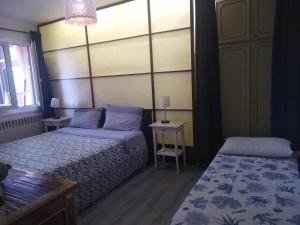 een slaapkamer met 2 bedden en een tafel bij appartamento centro storico in Monfalcone