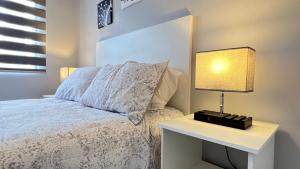 a bedroom with a bed and a table with a lamp at Habitación Plata #3 in Aguascalientes