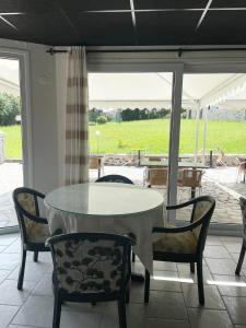 a table and chairs with a view of a patio at La Chatelleraie in Saint-Étienne-de-Maurs