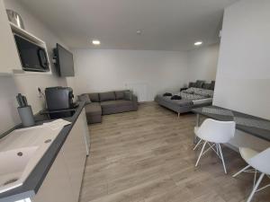 eine Küche und ein Wohnzimmer mit einem Sofa und einem Tisch in der Unterkunft Belvárosi apartmanház 2 in Szigetvár
