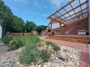 een patio met een bakstenen gebouw met een houten structuur bij Belvárosi apartmanház 2 in Szigetvár