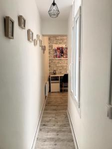 a hallway with white walls and wooden floors and a window at Street Home in Boulogne-sur-Mer
