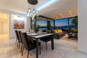 a dining room with a table and chairs and a couch at Apartment Magdalena in Malinska