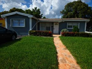a house with a green lawn in front of it at The Vacay Inn in Lauderdale Lakes
