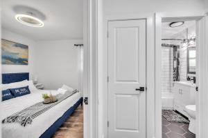 ein weißes Schlafzimmer mit einem Bett und einem Badezimmer in der Unterkunft Comforting Retreat Near Woodfield Mall home in Rolling Meadows