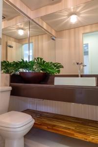 y baño con aseo, lavabo y espejo. en Apartamento Alto Padrão, en Balneário Camboriú