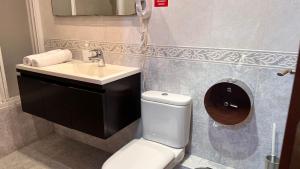 y baño con aseo blanco y lavamanos. en Hostal Madrazo, en Barcelona