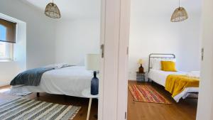 a white bedroom with a bed and a yellow blanket at OceanLand - Santa Cruz in Santa Cruz +63 photos