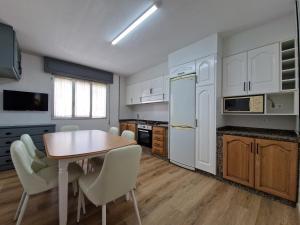 eine Küche mit einem Tisch und Stühlen im Zimmer in der Unterkunft Acogedor alojamiento en Sanxenxo in Sanxenxo
