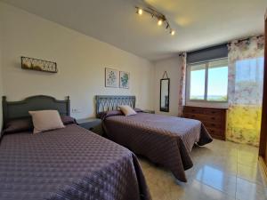 1 Schlafzimmer mit 2 Betten und einem Fenster in der Unterkunft Acogedor alojamiento en Sanxenxo in Sanxenxo