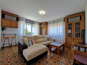 ein Wohnzimmer mit einem Sofa und einem Tisch in der Unterkunft Acogedor alojamiento en Sanxenxo in Sanxenxo