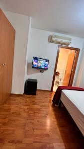 a bedroom with a bed and a tv on the wall at Hostal Madrazo in Barcelona