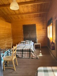 ein Schlafzimmer mit einem Bett in einer Holzhütte in der Unterkunft Granja escuela con Bungalows in San Martín de la Vega