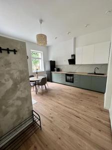 a large kitchen with a table and a dining room at Apartamenty Reja in Lębork