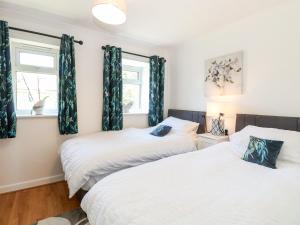 two beds in a room with two windows at Drifters Cove in Great Yarmouth