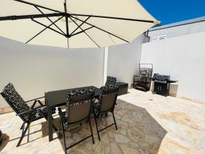 comedor con mesa y sombrilla en Lovely apartment Vila Zala en Kali