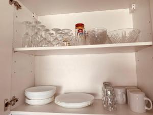 um armário cheio de copos, pratos e tigelas em Buena Vista Appartement en bord de mer em Argelès-sur-Mer