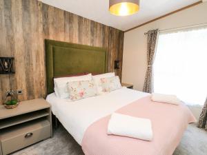 Un dormitorio con una gran cama blanca y una ventana en Saorsa, en Crieff