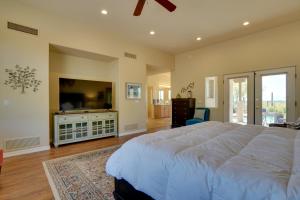 a bedroom with a large bed and a flat screen tv at Updated Tucson Home with Panoramic Mtn Views and Pool! in Tucson