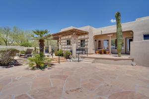 a house with a patio with a palm tree at Updated Tucson Home with Panoramic Mtn Views and Pool! in Tucson