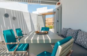 a dining room with a table and blue chairs at Erifili Houses in Faros