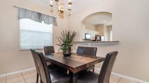uma sala de jantar com uma mesa de madeira e cadeiras em 8008 King Palm em Kissimmee