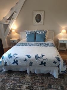 a bedroom with a bed with a blue and white bedspread at Rêves & Rivière in Rivière