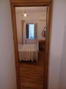 drzwi do sypialni z łóżkiem i oknem w obiekcie kirkis apartment w mieście Ágios Rókkos