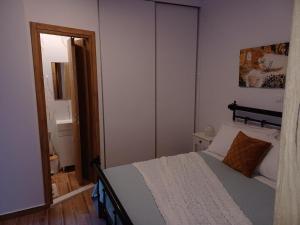 małą sypialnię z łóżkiem i lustrem w obiekcie kirkis apartment w mieście Ágios Rókkos