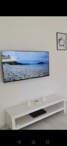sala de estar blanca con TV de pantalla plana en la pared en Quince, en Bor