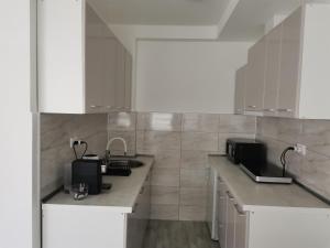 a kitchen with white cabinets and a counter top at Quince in Bor