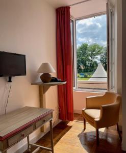 Habitación con escritorio, silla y ventana. en La Chatelleraie, en Saint-Étienne-de-Maurs