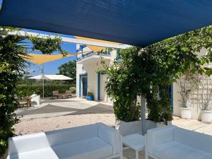 a patio with two white couches under a blue umbrella at Campitur in Campomarino