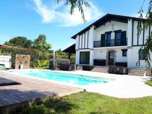 uma villa com piscina em frente a uma casa em SCI LOUXOR BY DOMINIQUE em Urrugne