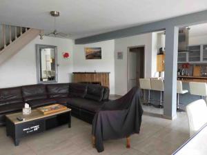uma sala de estar com um sofá de couro e uma mesa em SCI LOUXOR BY DOMINIQUE em Urrugne