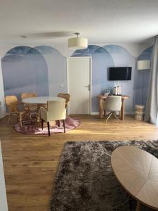 a living room with a table and chairs and a tv at Residhome Neuilly Bords De Marne in Neuilly-Plaisance