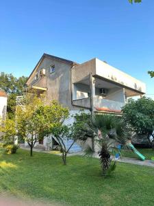 une maison avec un palmier en face dans l'établissement Apartmani Zelenika, à Herceg-Novi