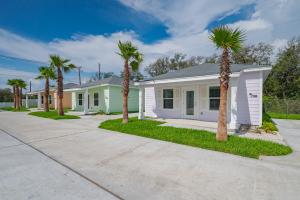 a row of palm trees in front of a house at The Oasis Resort in Rockport