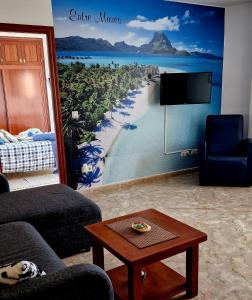 ein Wohnzimmer mit einem Wandbild eines Strandes in der Unterkunft RINCON DO MAR 1 DH in A Guarda