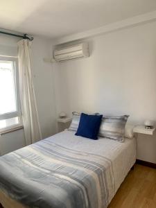 a bedroom with a bed with a blue pillow on it at Nice Home+Wifi+AC+Netflix in Valladolid