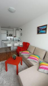 salon z kanapą i czerwonym stołem w obiekcie VIP Apartment Belvedere Club w mieście Bansko