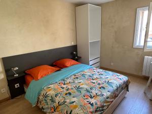 a bedroom with a bed with orange pillows at Rue Longue in La Côte-Saint-André
